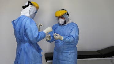 A member of a medical team wearing a protective suit takes a swab to test for the coronavirus disease (COVID-19) at a medical clinic in Tripoli, Libya June 10, 2020. REUTERS/Ismail Zitouny
