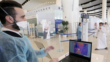 A security man looks at a screen showing the body temperature of travellers, at Riyadh International Airport on May 31, 2020. (Reuters)