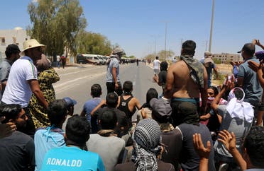 Tunisian protesters block a road leading to the center of Tataouine on June 23, 2020, during a gathering to demand the release of detained protesters who were tried for disrupting public order. (AFP)