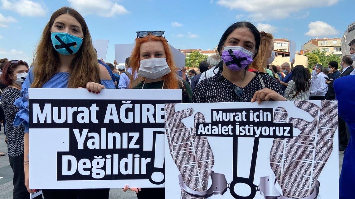 People hold placards that read Murat Agirel is not alone and we want justice for Murat outside the courthouse, in Istanbul, Wednesday, June 24, 2020. (AP)