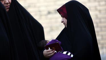 A woman holds her baby in southern Tehran on April 27, 2014. (File photo: AFP)