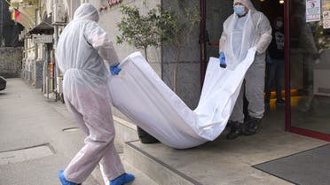 Forensic workers carry the body of Gholamreza Mansouri from a hotel downtown Bucharest, Romania. (AP)