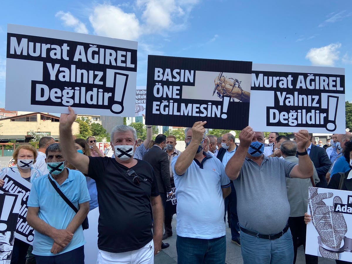 People hold placards that read Murat Agirel is not alone and we want justice for Murat outside the courthouse, in Istanbul, Wednesday, June 24, 2020. (AP)