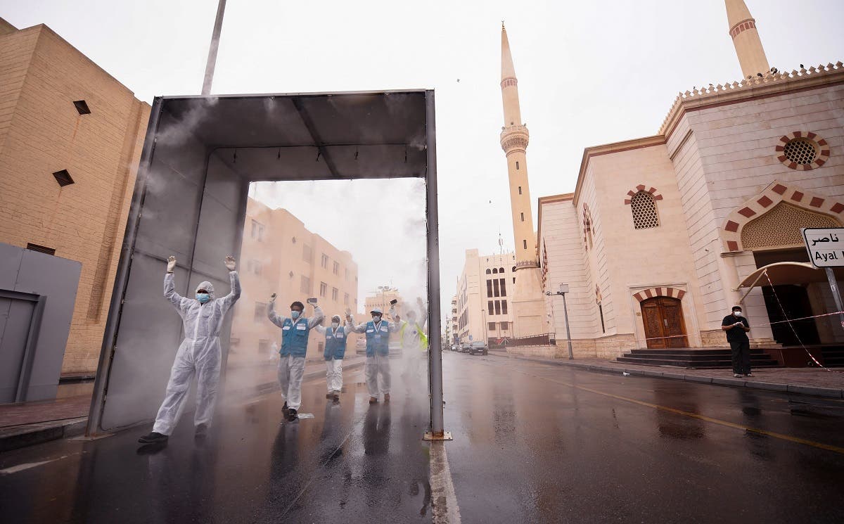 Health volunteers pass through a sterilisation chamber installed to disinfect residents entering and leaving the Naif area in the Gulf emirate of Dubai during the COVID-19 coronavirus outbreak, on April 15, 2020. (AFP)
