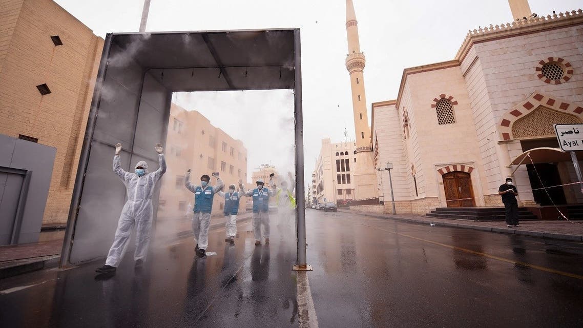 Health volunteers pass through a sterilisation chamber installed to disinfect residents entering and leaving the Naif area in the Gulf emirate of Dubai during the COVID-19 coronavirus outbreak, on April 15, 2020. (AFP)