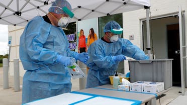 In this April 2, 2020, file photo, registered nurses Jonathan Fisk, left, and Patrick LaFontaine set up a COVID-19 testing station for pre-screened pediatric patients outside a Children's Health PM Urgent Care facility in Richardson, Texas. (AP)