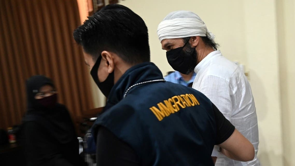 Wissam Barakeh (R) is arrested by Immigration officer before a press conference at the Immigration Detention House in Jimbaran, Bali, Indonesia, June 24, 2020. (AFP)