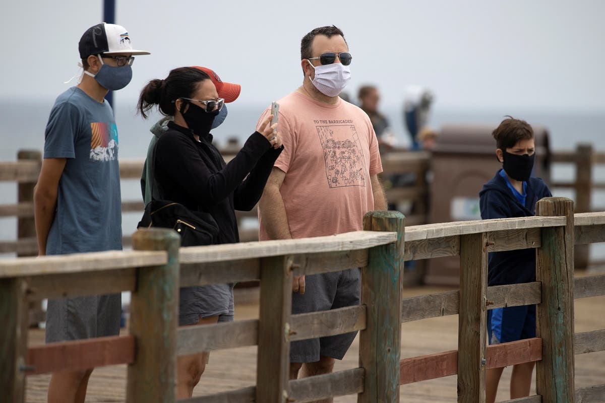 People wear masks as they walk on the ocean pier during the global outbreak of the coronavirus in Oceanside, California, US, June 22, 2020. (Reuters)
