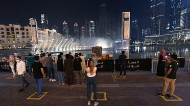 people observe social distancing while gathering to watch the Dubai fountain show which resumes as the Gulf emirate emerges from a lockdown imposed due to the COVID-19 pandemic, UAE, June 2, 2020. (AFP)