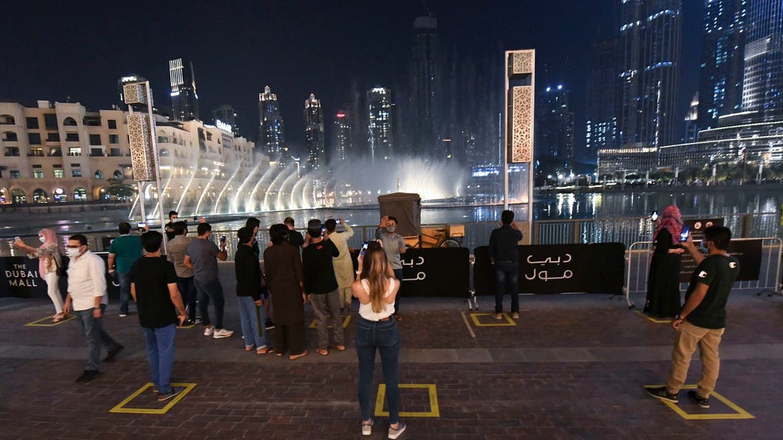 people observe social distancing while gathering to watch the Dubai fountain show which resumes as the Gulf emirate emerges from a lockdown imposed due to the COVID-19 pandemic, UAE, June 2, 2020. (AFP)