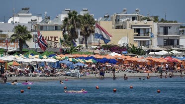Tourists enjoy the sun and sea on a beach on the Greek Island of Kos on July 22, 2017. (AFP)
