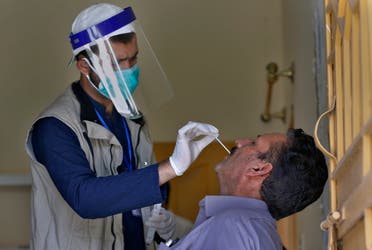 A health worker takes a swab sample of a person during door-to-door testing and screening facility for the new coronavirus, in Islamabad, Pakistan, Monday, June 15, 2020. (AP)