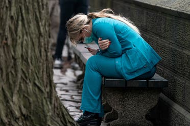 A healthcare worker sits on a bench near Central Park in the Manhattan borough of New York City, US, March 30, 2020. (Reuters)