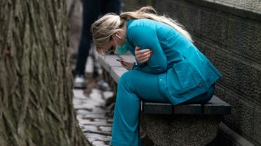 A healthcare worker sits on a bench near Central Park in the Manhattan borough of New York City, US, March 30, 2020. Reuters