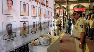 An Indian police officer pays his respects to police and uniformed personnel who lost their lives in 2008 terror attacks outside a railway station in Mumbai on November 26, 2012. (AFP)