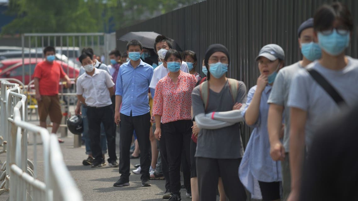 People wear masks as they wait in line to undergo COVID-19 coronavirus swab tests at a testing station in Beijing on June 28, 2020. Beijing has partially lifted weeks-long lockdown imposed in the Chinese capital to head off a feared second wave of coronavirus infections after three million samples were taken in two weeks, officials said. Dozens of residential compounds across the city were shut down, with authorities rolling out a mass testing campaign to root out any remaining cases.