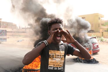 Sudanese men burn tires during a demonstration to commemorate the first anniversary of a deadly crackdown carried out by security forces on protesters during a sit-in outside the army headquarters, in Khartoum. (AP)
