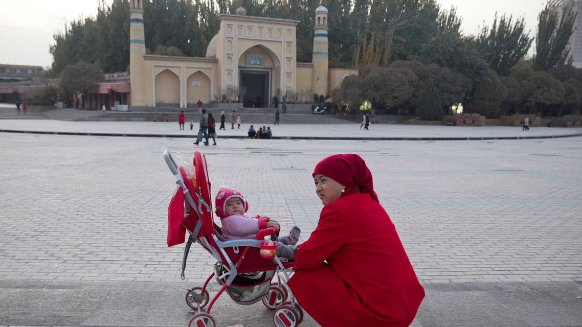 A woman tends to her child near the Id Kah Mosque in Kashgar in western China's Xinjiang region. (AP)