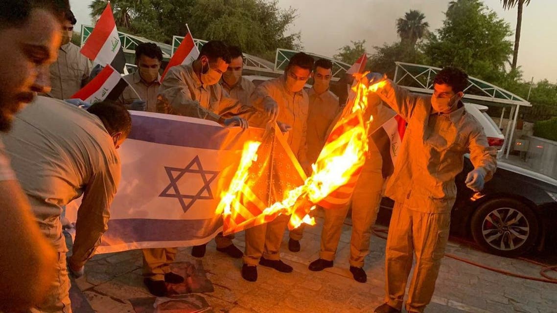 Detained Kata'ib Hezbollah fighters burn US flag upon release. (Photo via @iraqitweet/Twitter)