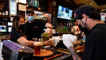 Jessica Ciaramitaro, Daryn Feenstra and Nicholas Soriano mix drinks while wearing face masks at the bar at San Pedro Brewing Company on Friday, May 29, 2020, in the San Pedro area of Los Angeles. (AP)