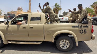 Fighters loyal to Libya's UN-recognised Government of National Accord (GNA) pose for a picture as they sit in the back of a pickup truck in the town of Tarhuna, about 65 kilometres southeast of the capital Tripoli on June 5, 2020, after the area was taken over by pro-GNA forces from rival forces loyal to strongman Khalifa Haftar. The GNA said on June 5 that it was back in full control of Tarhouna, the last stronghold of the forces of eastern strongman Khalifa Haftar. The UN-recognised government had announced the day before that they were also in full control of the capital Tripoli and its surroundings.