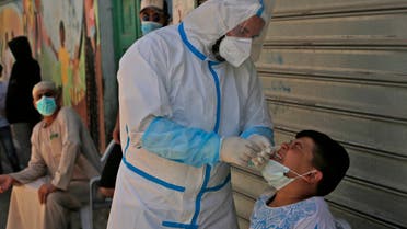 A medical worker affiliated with the Palestinian health ministry collects samples to test for the Covid-19 coronavirus in a mobile position in al-Azza Refugee Camp in the West Bank city of Bethlehem, on June 24, 2020. Coronavirus cases in the West Bank have more than doubled in a week, the Palestinian Authority said after warning a second wave of infections could be worse than the first.