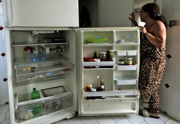 A Lebanese woman displays the content of her refrigerator at her apartment in Jounieh, north of the capital Beirut, on June 19, 2020. (AFP)