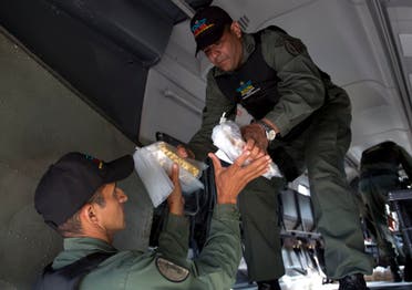 Military personnel remove gold bars from a military plane to be taken to Venezuela's Central Bank, at the Carlota military airport in Caracas on March 1, 2018. (AP)