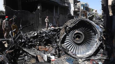 Security personnel beside the wreckage of a plane at the site after a Pakistan International Airlines aircraft crashed in a residential area, in Karachi. (File Photo: AFP)