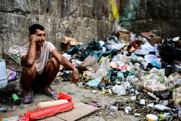 A man waits to get some food at a garbage dump in Las Minas de Baruta neighborhood, Caracas, Venezuela, on March 14, 2019. (AFP)
