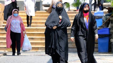 Pedestrians wearing protective masks due to the COVID-19 coronavirus, walk along a street in the Iranian capital Tehran on June 28, 2020. Iran's President Hassan Rouhani said today that mask-wearing will be mandatory in certain areas as of next week and gave virus-hit provinces the green light to reimpose restrictive measures.