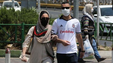 Pedestrians wearing protective masks due to the COVID-19 coronavirus, cross a street in the Iranian capital Tehran on June 28, 2020. Iran's President Hassan Rouhani said today that mask-wearing will be mandatory in certain areas as of next week and gave virus-hit provinces the green light to reimpose restrictive measures.