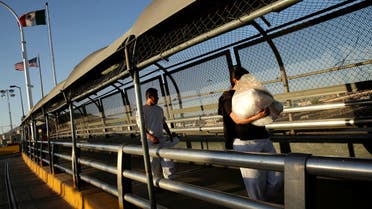 Mexican immigrants walk across the Paso del Norte border bridge after being deported from the United States amid the spread of the coronavirus disease (COVID-19), in Ciudad Juarez, Mexico April 29, 2020. REUTERS/Jose Luis Gonzalez