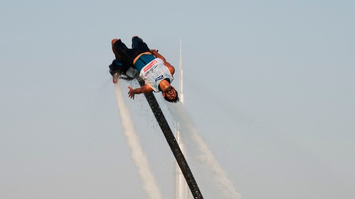 A man rides a flyboard with the Burj Khalifa, the world's tallest building, in the distance in Dubai, United Arab Emirates, Thursday, June 25, 2020. (AP)