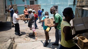Residents help to unload boxes of basic food staples, such as pasta, sugar and flour, provided by a government food assistance program, in Caracasâ€™ slum of Petare, Venezuela, Thursday, April 30, 2020. (AP)