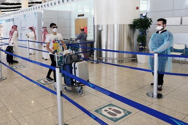 A traveller wearing a protective face mask wheels his bags at Riyadh International Airport, after Saudi Arabia reopened domestic flights in Riyadh, Saudi Arabia May 31, 2020. (Reuters)