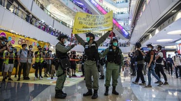  شرطة مكافحة الشغب ترفع تحذيرا خلال مظاهرة في مركز تجاري في هونغ كونغ في 6 يوليو 2020 ، ردًا على قانون الأمن القومي الجديد