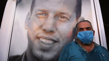 An Iraqi demonstrator wearing a face mask to protect agaisnt the Covid-19 coronavirus, attends a symbolic funeral for slain Iraqi jihadism expert Hisham al-Hashemi. (AFP)