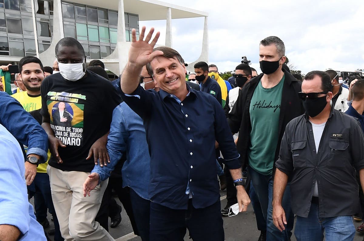 In this file photo taken on May 24, 2020 Brazil's President Jair Bolsonaro greets supporters upon arrival at Planalto Palace in Brasilia, amid the COVID-19 coronavirus pandemic. (AFP)