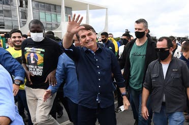 In this file photo taken on May 24, 2020 Bolsonaro greets supporters upon arrival at Planalto Palace in Brasilia, amid the COVID-19 coronavirus pandemic. (AFP)