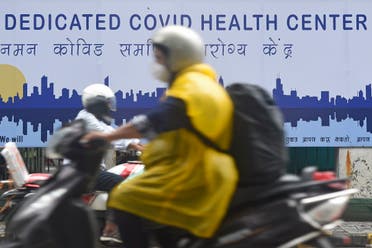 Commuters ride past a coronavirus health center in Mumbai on July 7, 2020. (AFP)