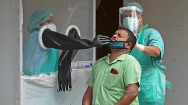 Health officials collect a swab sample from a man to test for the COVID-19 coronavirus, at a testing centre behind an open area of a government-run Sarojini Devi Eye Hospital, in Hyderabad on July 8, 2020. India on July 6 became the country with the third-highest coronavirus caseload in the world, as a group of scientists said there was now overwhelming evidence that the disease can be airborne -- and for far longer than originally thought.
