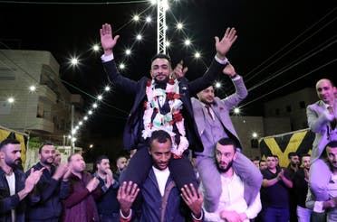 Palestinian groom Basel Abu al-Halawa celebrates with friends and family during a belated wedding party in front of his house in the West Bank city of Hebron. (AFP)