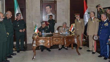 A handout picture released by the official Syrian Arab News Agency (SANA) on July 8, 2020, shows Iranian Armed Forces Chief of Staff Major General Mohammad Bagheri (L) and Syria's Defense Minister Ali Ayoub signing a bilateral military deal in Damascus. (AFP)