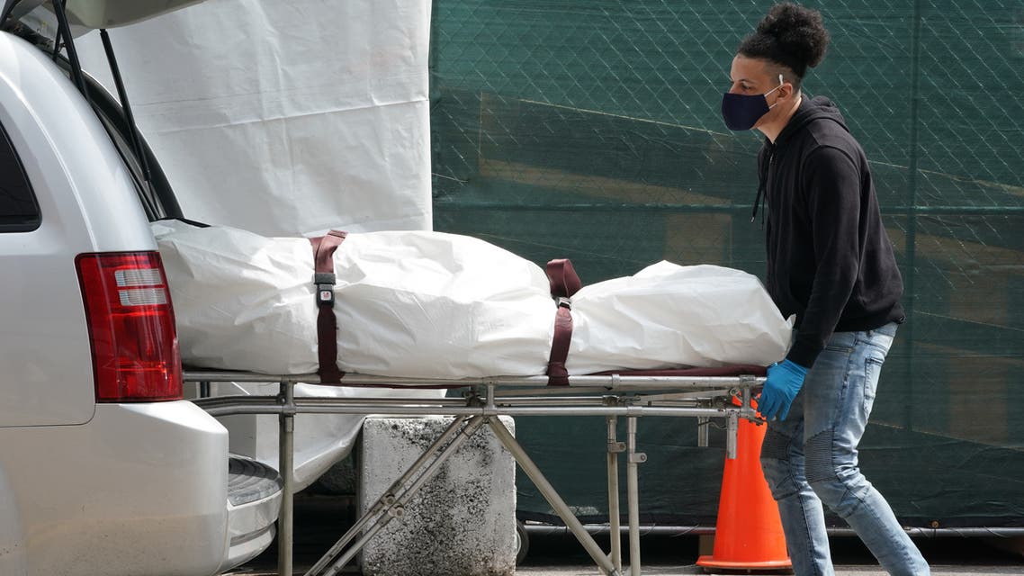 (FILES) In this file photo taken on April 8, 2020, a body is moved from a refrigeration truck serving as a temporary morgue to a vehicle at the Brooklyn Hospital Center, in the Borough of Brooklyn in New York. The United States passed another grim coronavirus milestone on July 6, 2020 as the death toll from the virus climbed past 130,000, according to a tally kept by Johns Hopkins University.