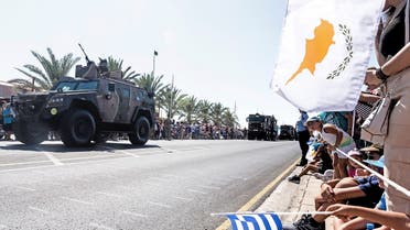  In this file photo taken on October 1, 2019 Greek (C) and Cypriot (R) national flags wave as military trucks takes part in a military parade marking the 59th anniversary of Cyprus' independence from British colonial rule, in the capital Nicosia. (AFP)