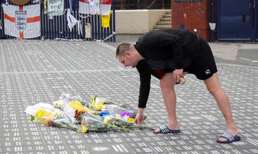 A man lays flowers on the ground in memory of Jack Charlton at Leeds United Stadium Elland Road, in Leeds, Britain, on July 11, 2020. (Reuters)