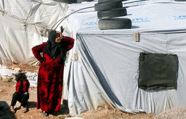 A Syrian refugee woman stands outside a tent at a camp in Bar Elias, in the Bekaa Valley, Lebanon January 13, 2020. (Reuters)