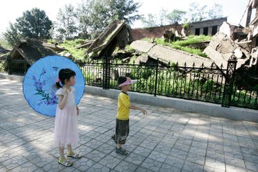 Two children look at ruins of Hebei Polytechnic University library in Tangshan. (Reuters)