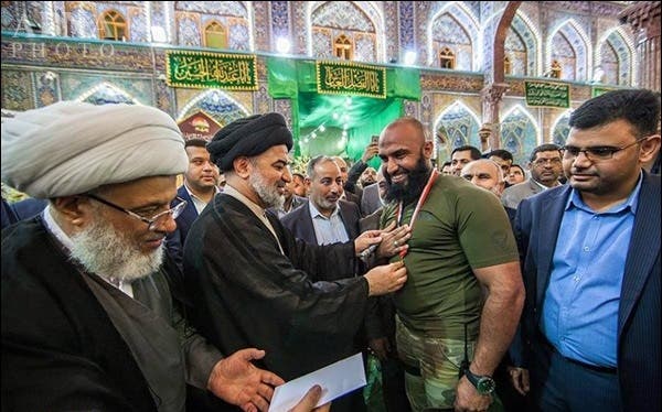 ابوعزرائيل در حال گرفتن مدال از یک روحانی